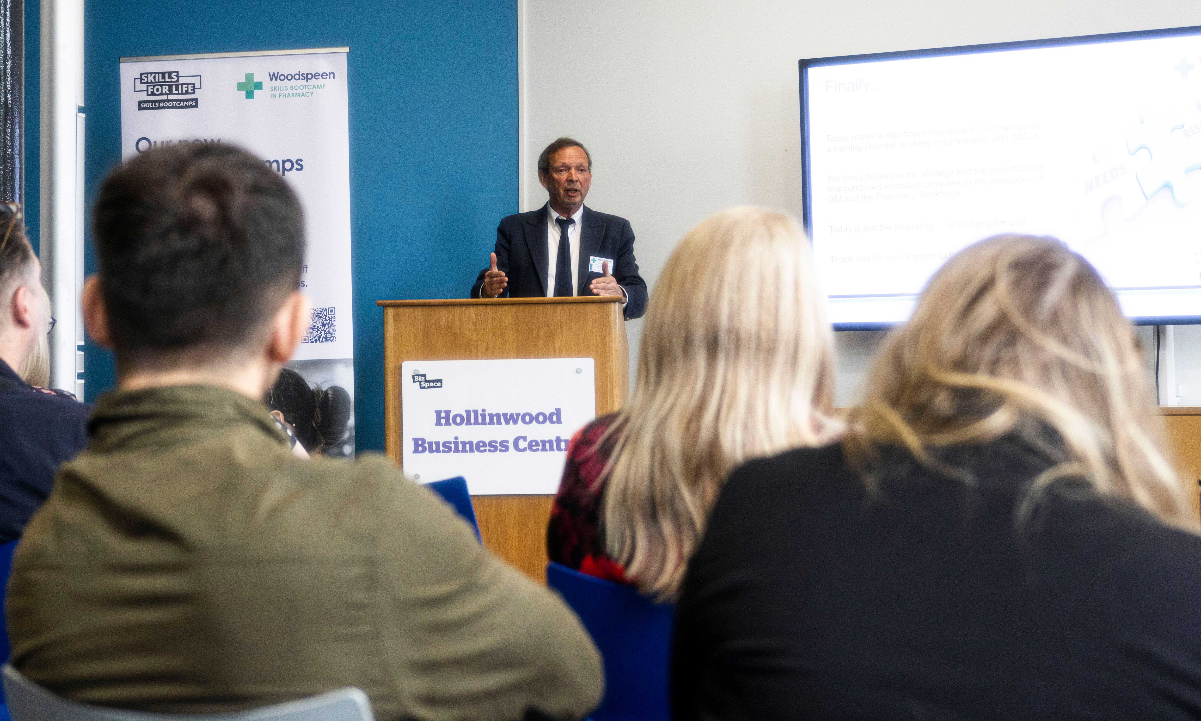 Ian Strachan standing behind podium speaking at the launch for the Skills Bootcamp in Pharmacy